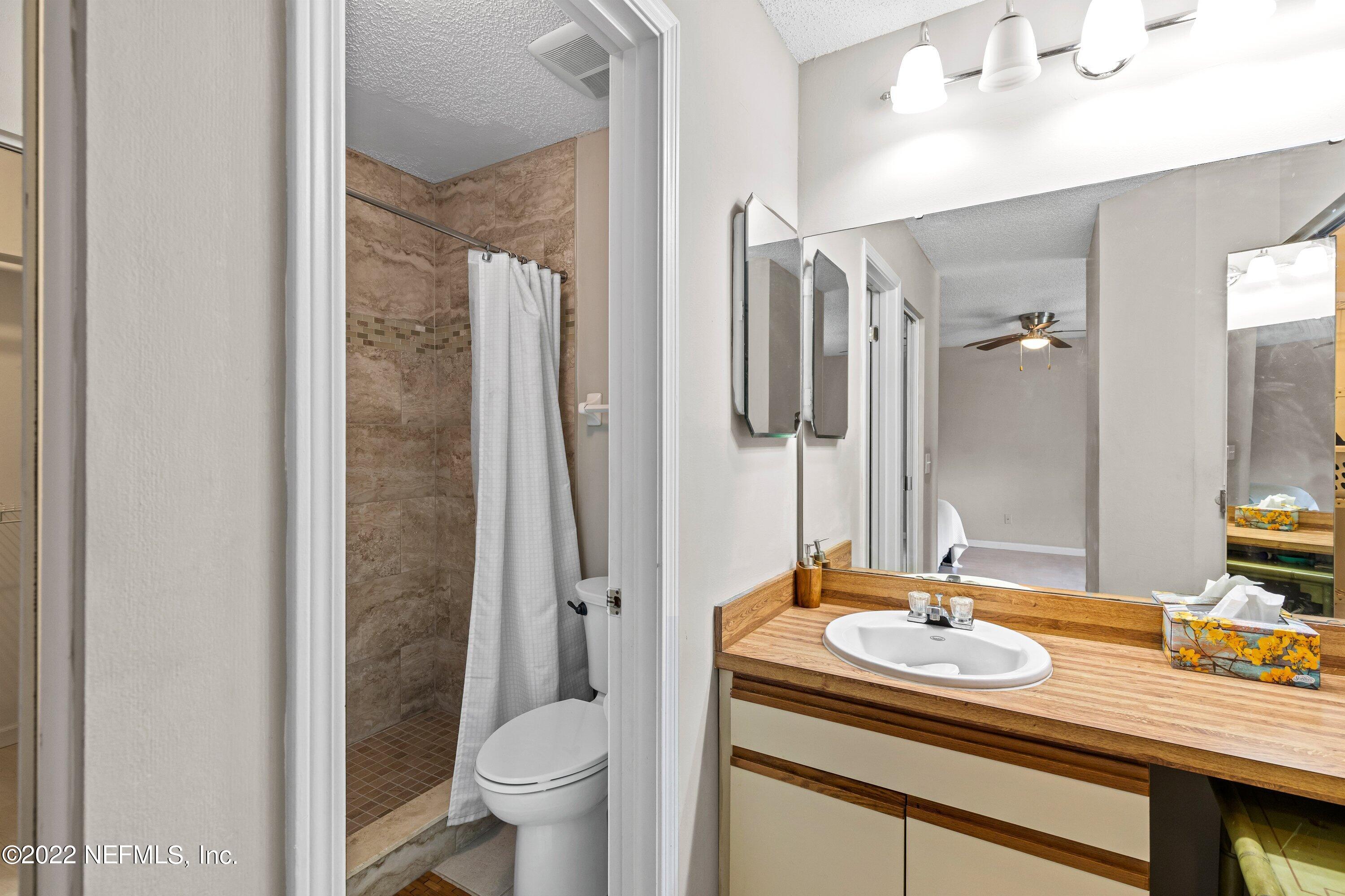 3801 Crown Point Road, Unit 2214 Jacksonville, FL 32257 - Photo 15 of 27 a bathroom with a sink toilet a mirror and shower