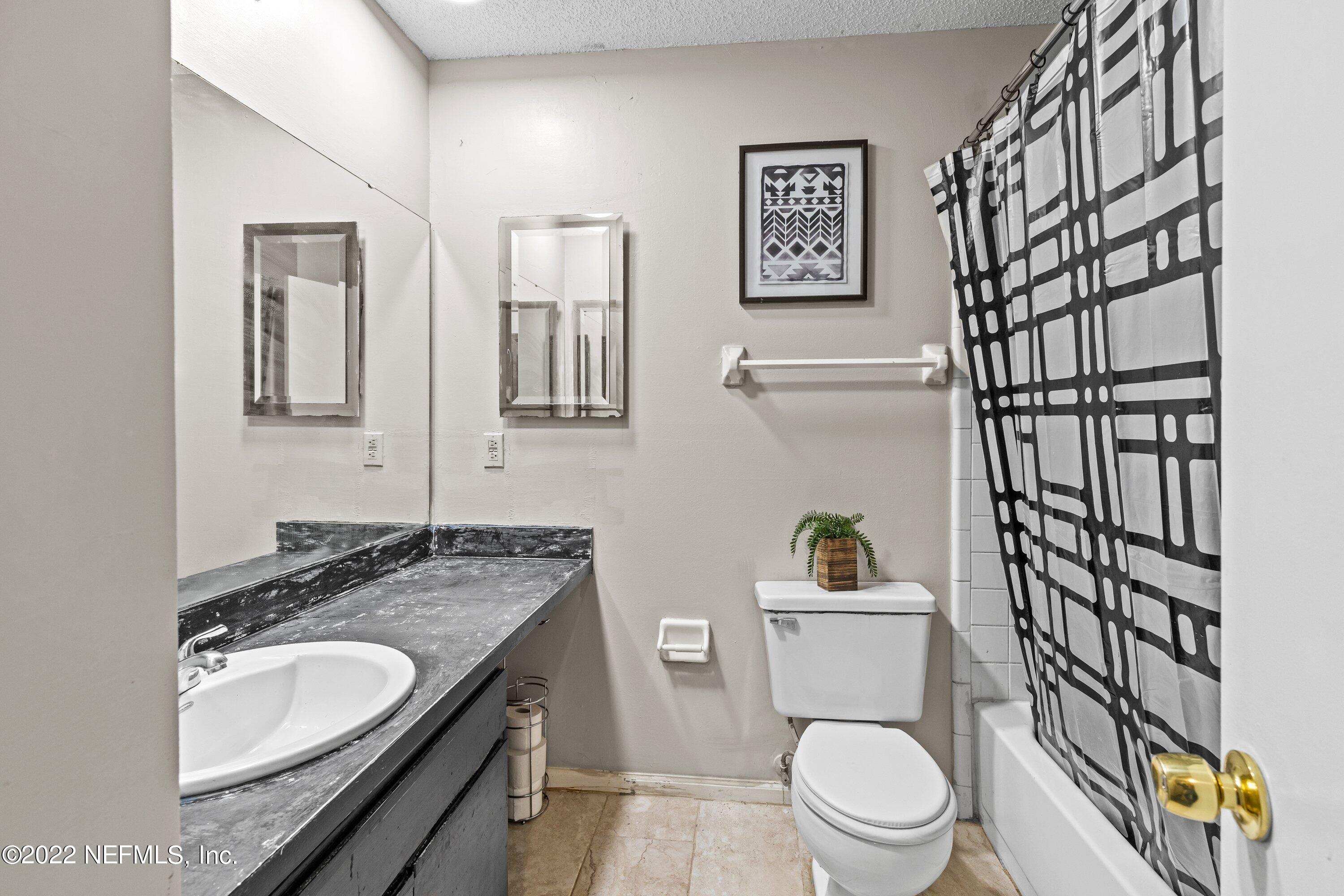 3801 Crown Point Road, Unit 2214 Jacksonville, FL 32257 - Photo 18 of 27 a bathroom with a granite countertop toilet sink and mirror