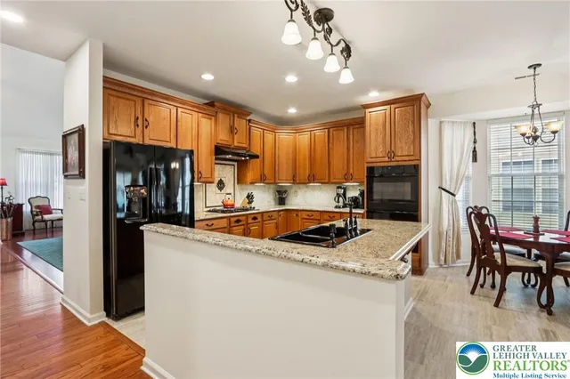 a kitchen with stainless steel appliances granite countertop a refrigerator stove and sink