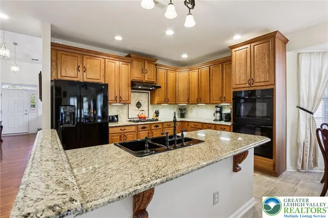 a kitchen with granite countertop a sink cabinets and stainless steel appliances