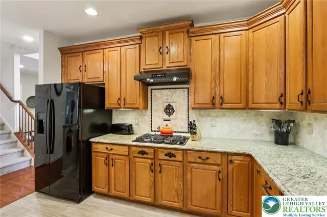 a kitchen with granite countertop a table chairs stove and refrigerator