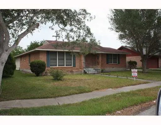 a view of a yard in front of a house with large trees