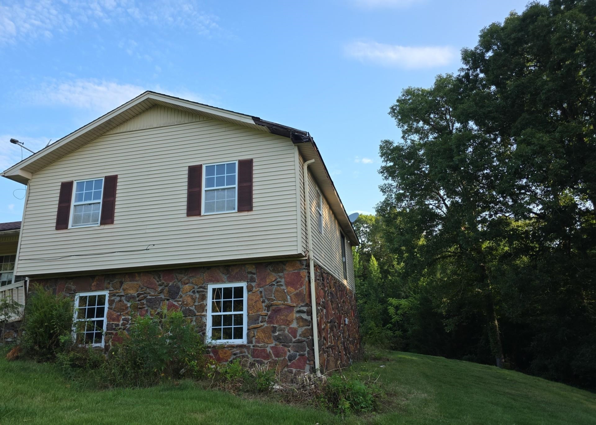 Two-story exterior with horizontal siding and a stone-finish foundation