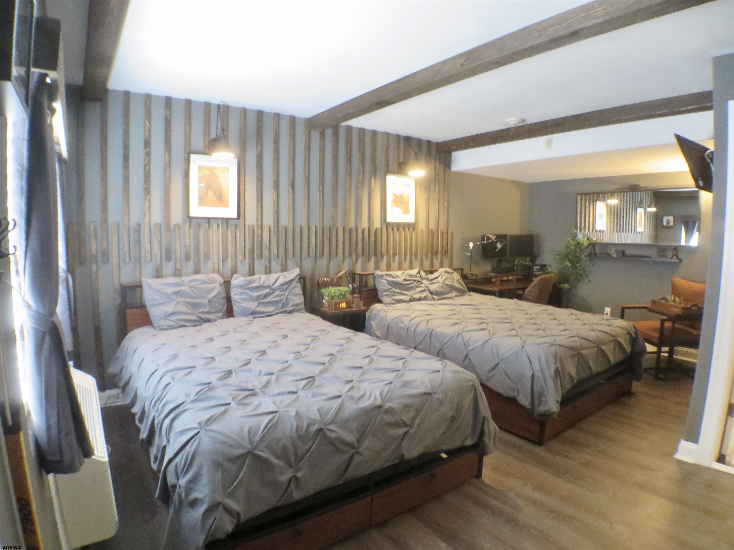 900 Wesley Avenue, Unit 103 Ocean City, NJ 08226 - Photo 2 of 15 a large bedroom with two beds and large windows