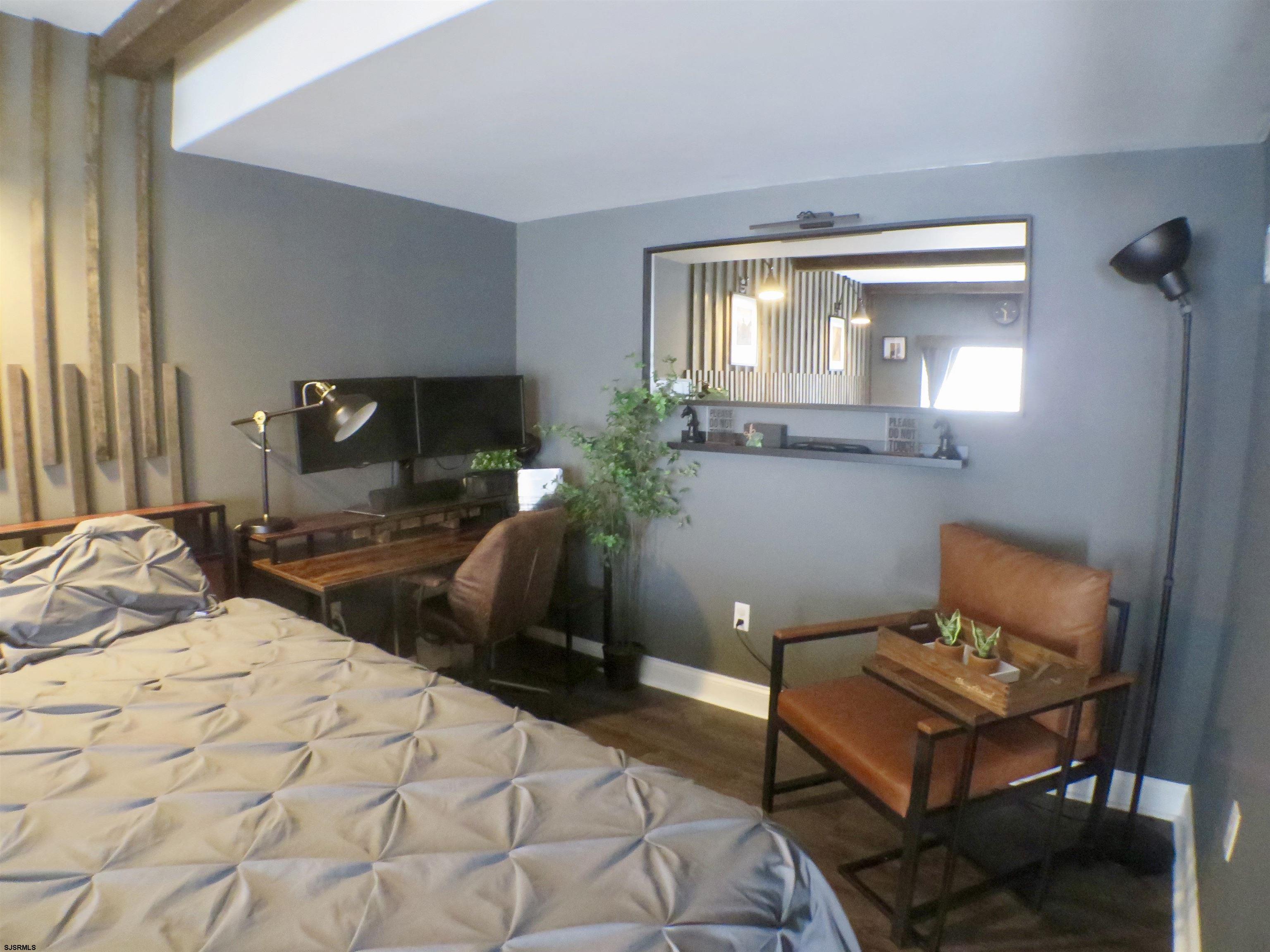 900 Wesley Avenue, Unit 103 Ocean City, NJ 08226 - Photo 3 of 15 a bedroom with a bed window and chair