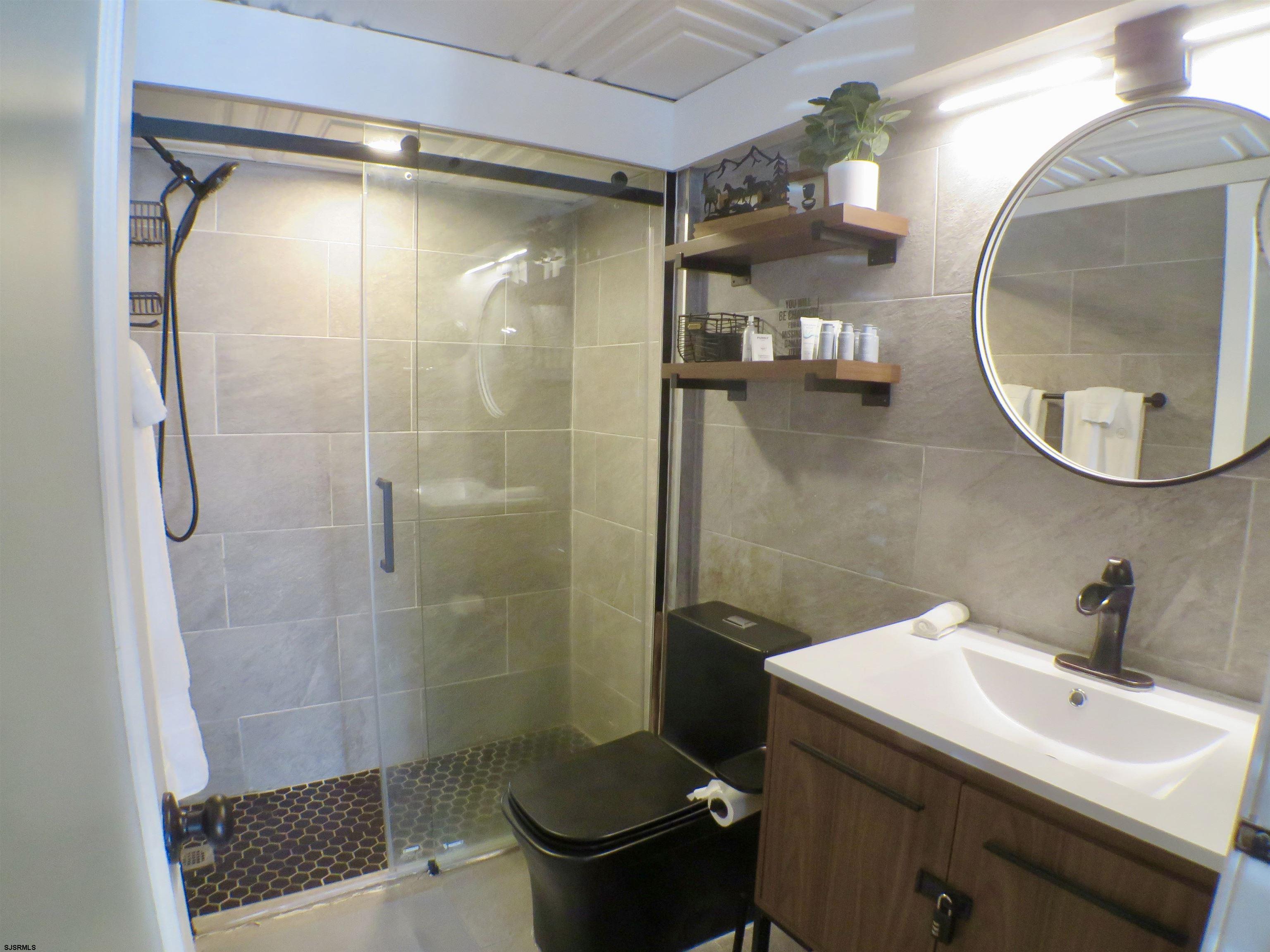 900 Wesley Avenue, Unit 103 Ocean City, NJ 08226 - Photo 9 of 15 a bathroom with a sink toilet and shower