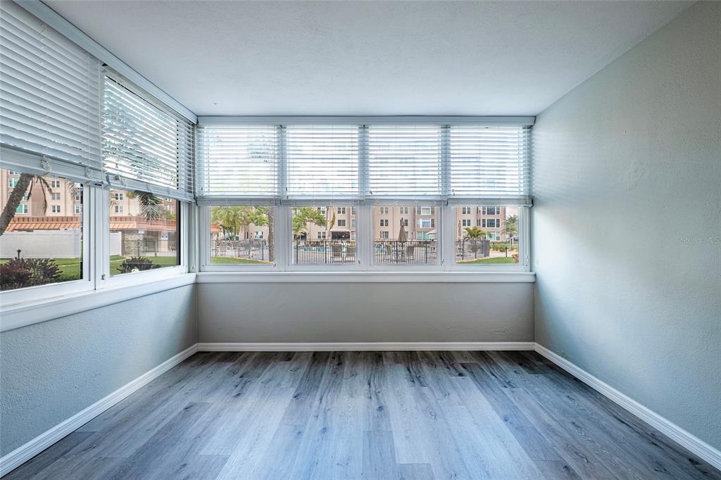 620 Edgewater Drive, Unit 103 Dunedin, FL 34698 - Photo 12 of 26 an empty room with wooden floor and windows