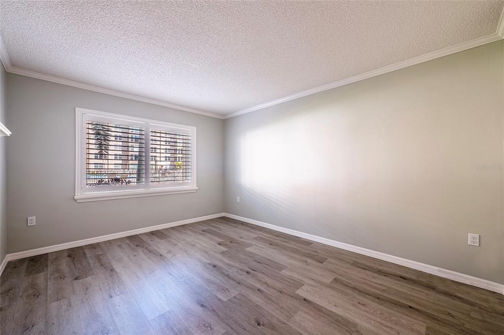 620 Edgewater Drive, Unit 103 Dunedin, FL 34698 - Photo 14 of 26 a view of an empty room with wooden floor and a window
