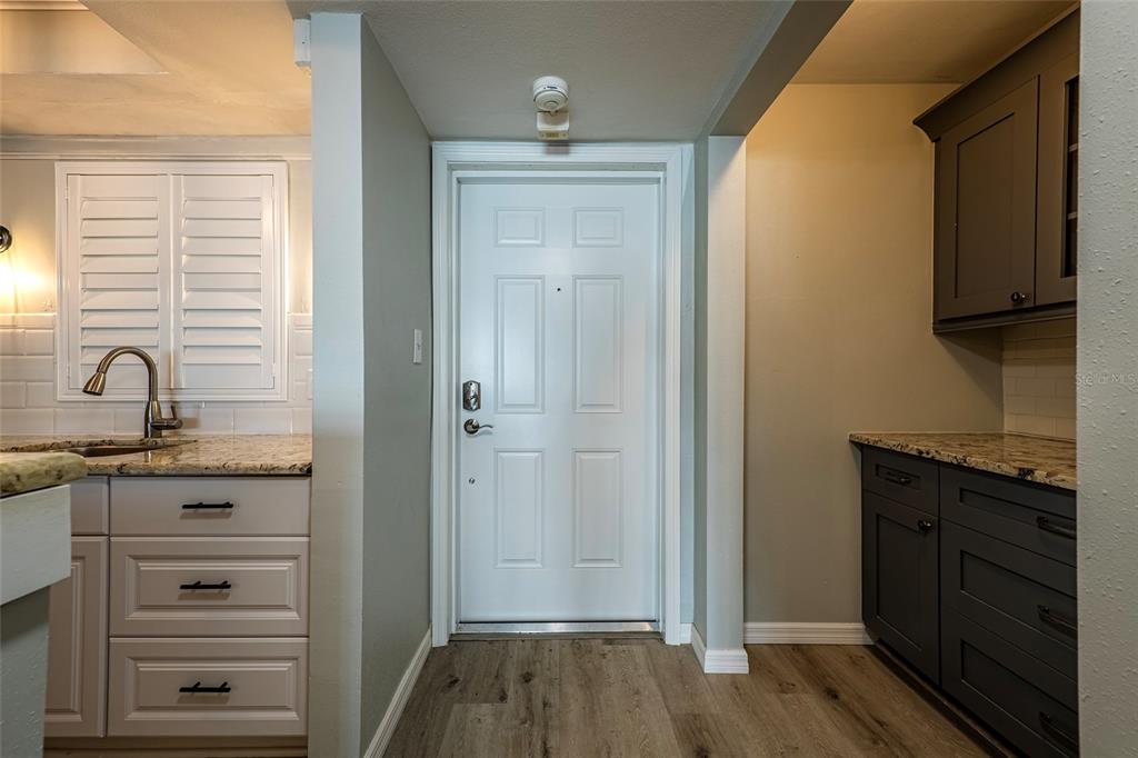 620 Edgewater Drive, Unit 103 Dunedin, FL 34698 - Photo 3 of 26 a room with granite countertop a sink and a mirror