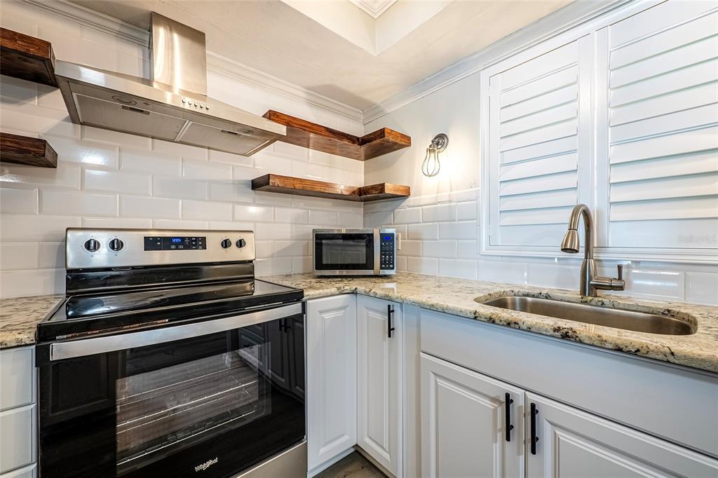 620 Edgewater Drive, Unit 103 Dunedin, FL 34698 - Photo 4 of 26 a kitchen with a stove and a sink