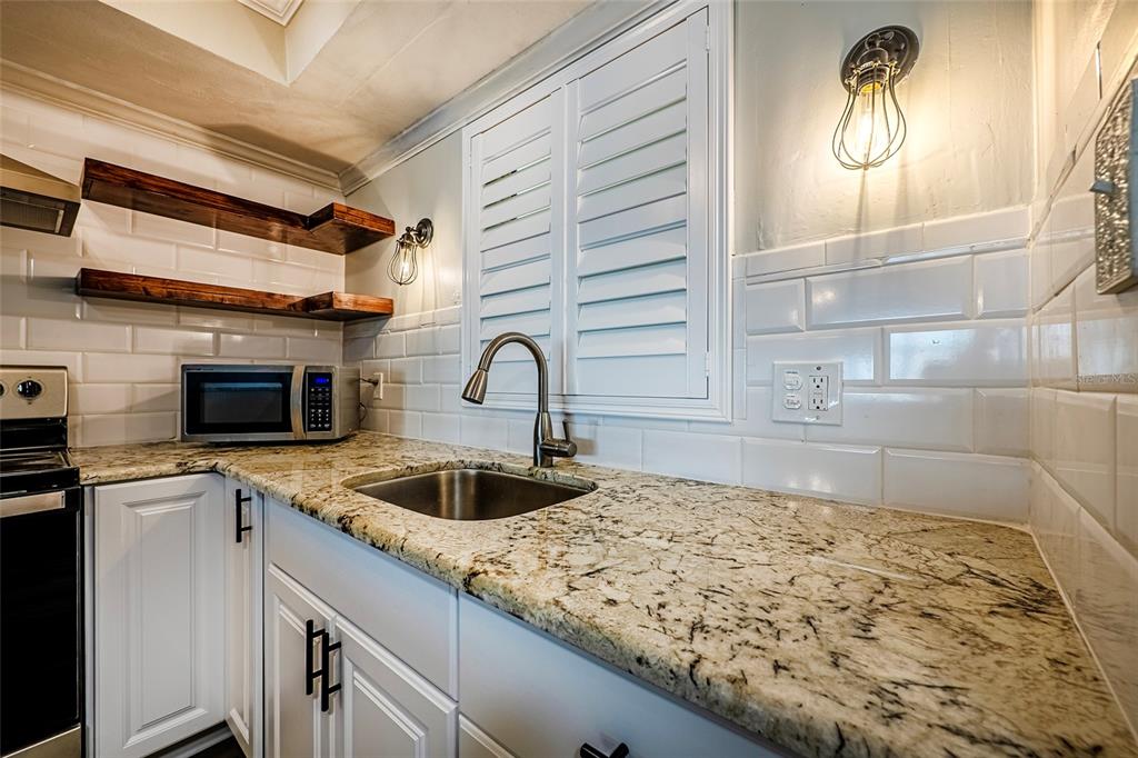 620 Edgewater Drive, Unit 103 Dunedin, FL 34698 - Photo 6 of 26 a kitchen with a sink and cabinets