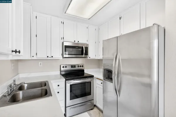 a kitchen with a refrigerator stove and white cabinets