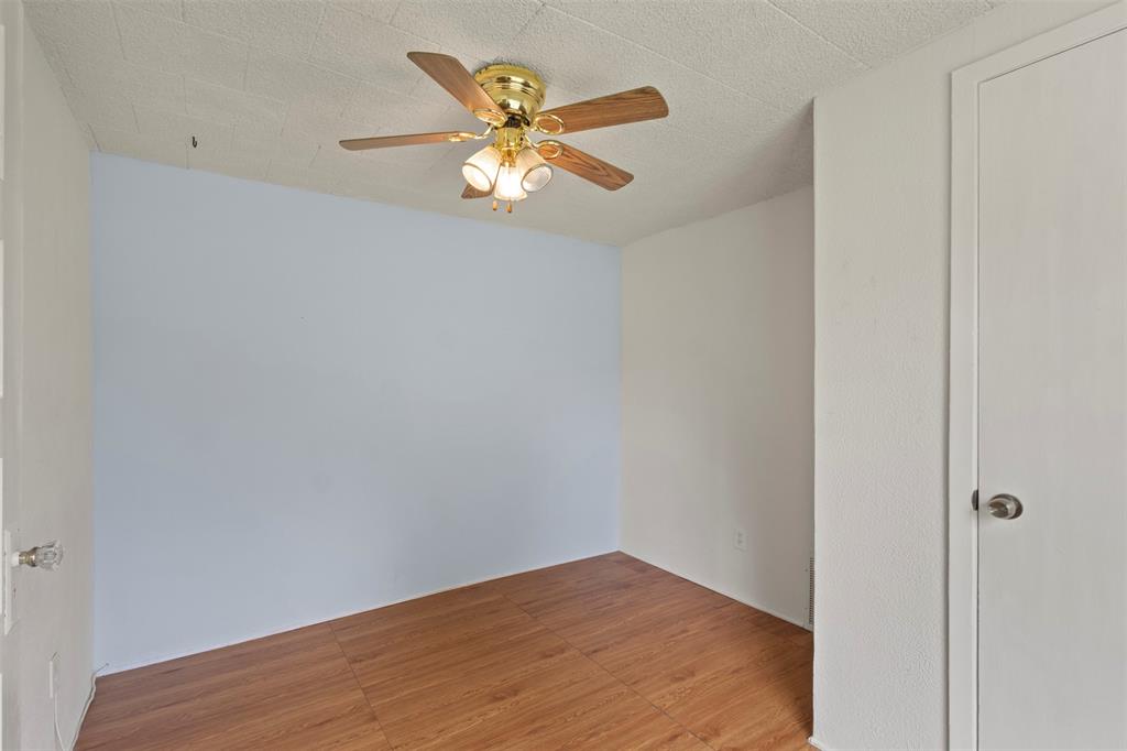 829 West 9th Street Bonham, TX 75418 - Photo 19 of 30 Room featuring wood-finish flooring, a ceiling fan with light fixture, and a solid white door with a round knob