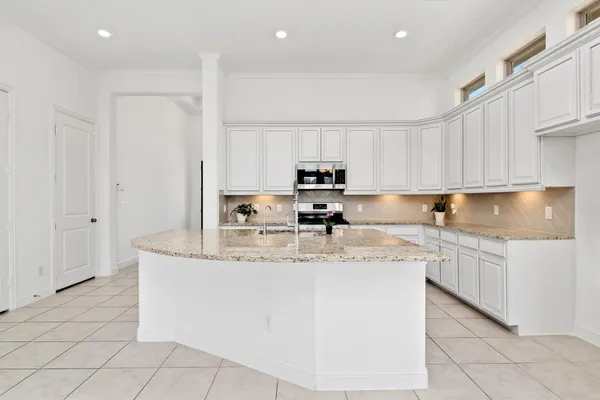 a kitchen with stainless steel appliances granite countertop a sink a stove and a refrigerator