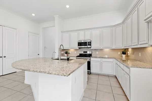 a kitchen with stainless steel appliances granite countertop a sink stove and cabinets