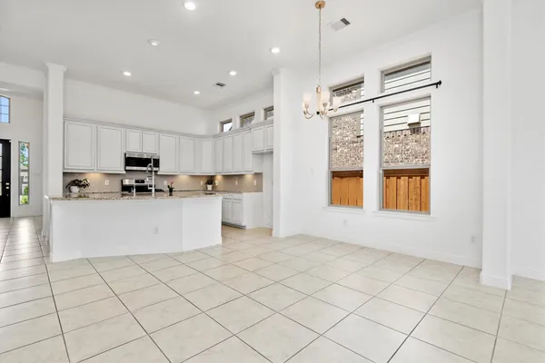 a view of kitchen with stainless steel appliances cabinets and large window