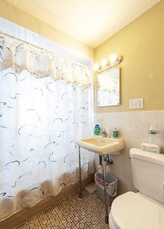 223 Ferry Street Everett, MA 02149 - Photo 12 of 24 a bathroom with a sink toilet and a mirror