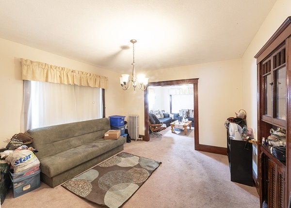 223 Ferry Street Everett, MA 02149 - Photo 16 of 24 a living room with furniture a chandelier and a flat screen tv
