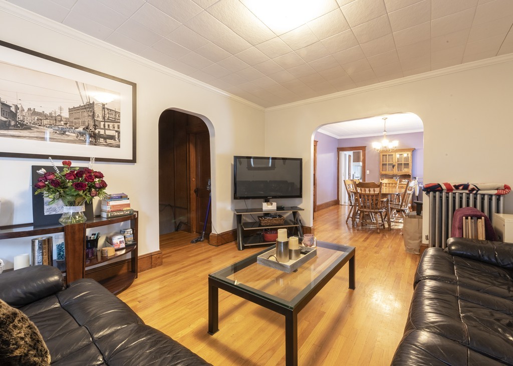 223 Ferry Street Everett, MA 02149 - Photo 4 of 24 a living room with furniture a flat screen tv and a table