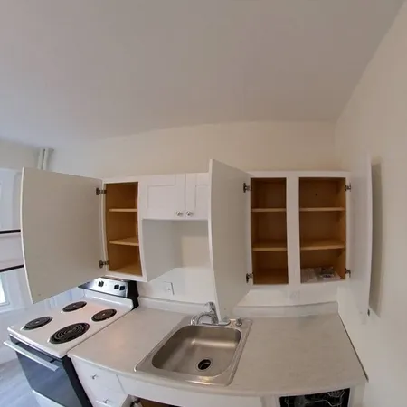a white kitchen with a sink and a refrigerator