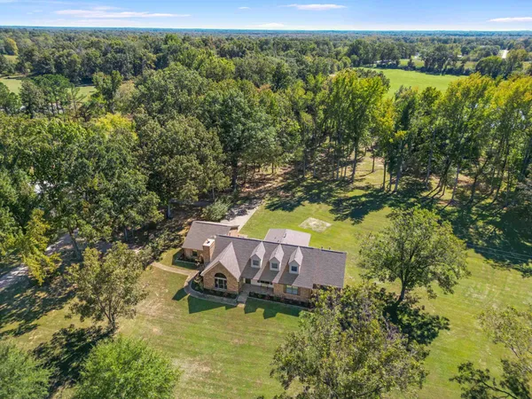 an aerial view of a house with a yard swimming pool and outdoor seating