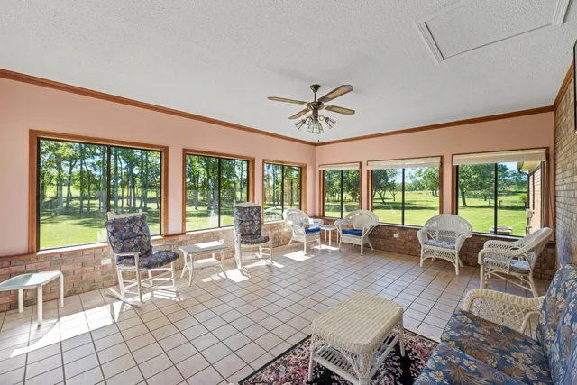 a living room with furniture and floor to ceiling windows