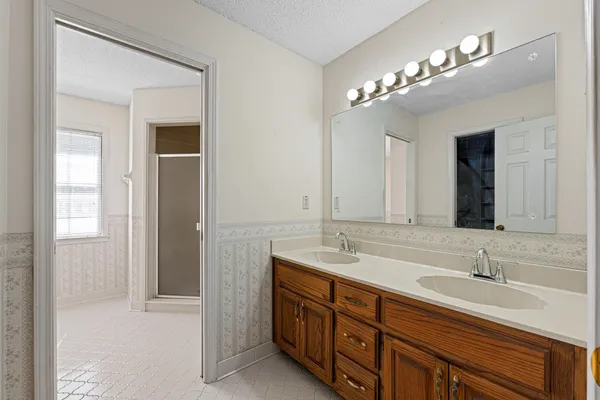 a bathroom with double vanity sink a vanity and a large mirror
