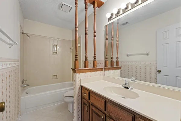 a bathroom with a granite countertop sink a toilet and shower
