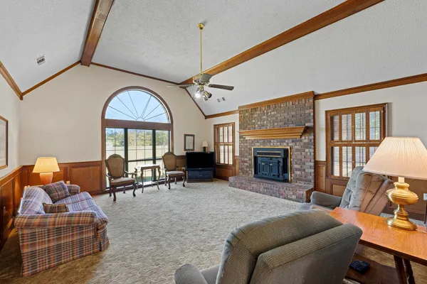 a living room with furniture a fireplace and a large window