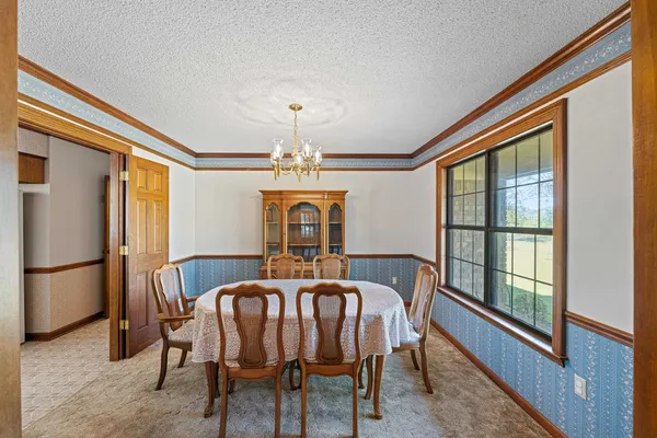 a dining room with furniture a chandelier and window
