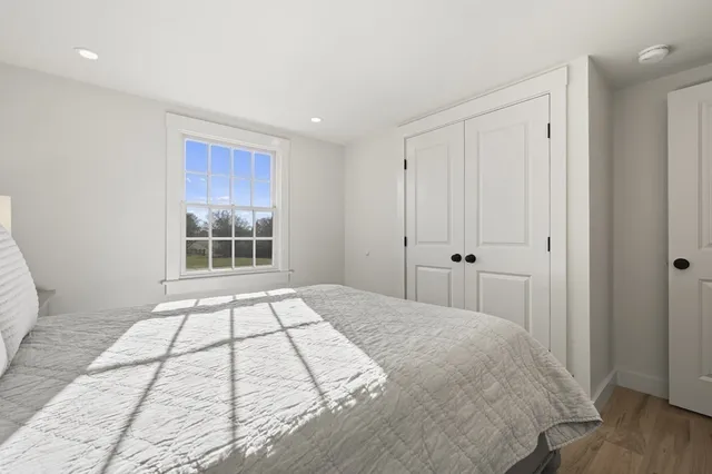 a view of a bedroom with a bed and wooden floor