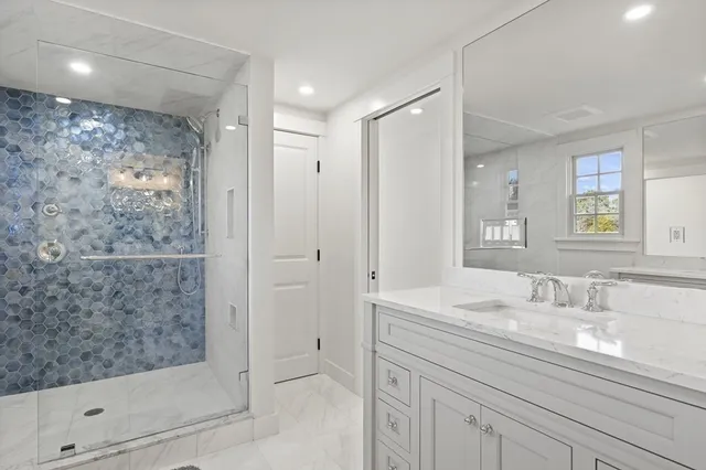 a bathroom with a shower sink and mirror