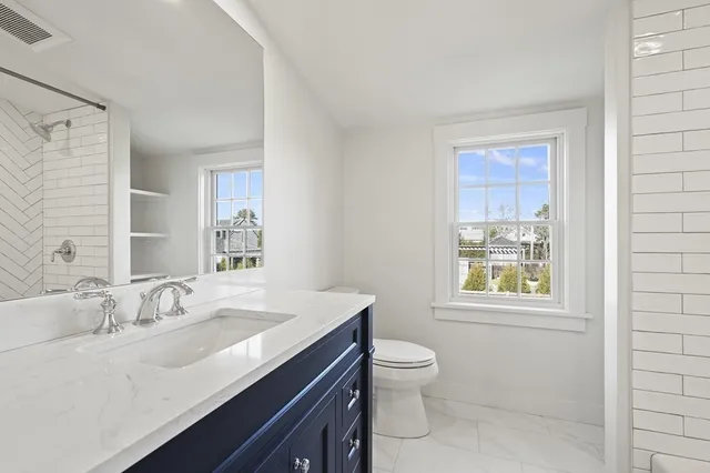 a bathroom with a granite countertop sink toilet and shower