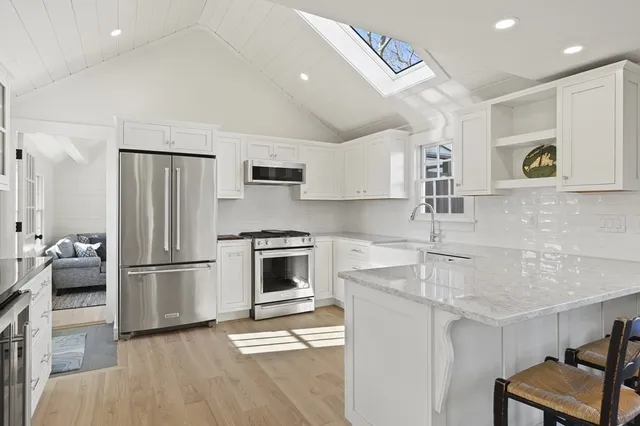 a kitchen with stainless steel appliances granite countertop a refrigerator and a stove top oven