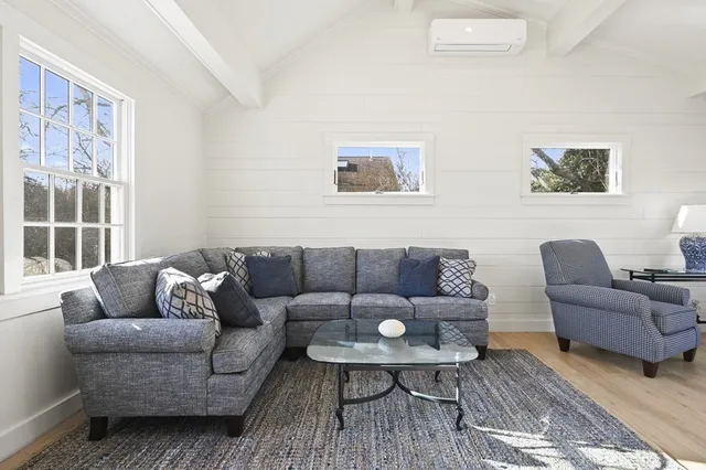 a living room with furniture wooden floor and window