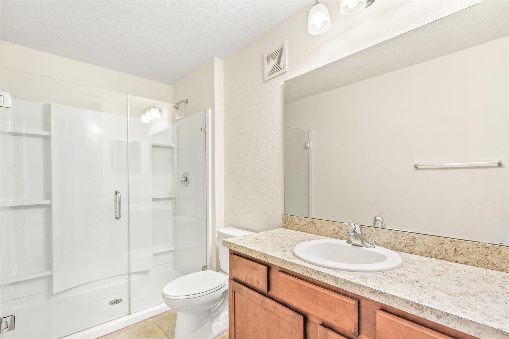 1511 Golden Lake Loop St. Augustine, FL 32084 - Photo 14 of 30 a bathroom with a granite countertop sink a toilet a mirror and shower