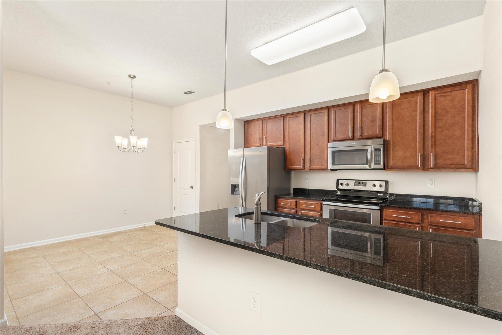 1511 Golden Lake Loop St. Augustine, FL 32084 - Photo 5 of 30 a kitchen with stainless steel appliances a stove a sink cabinets and a refrigerator