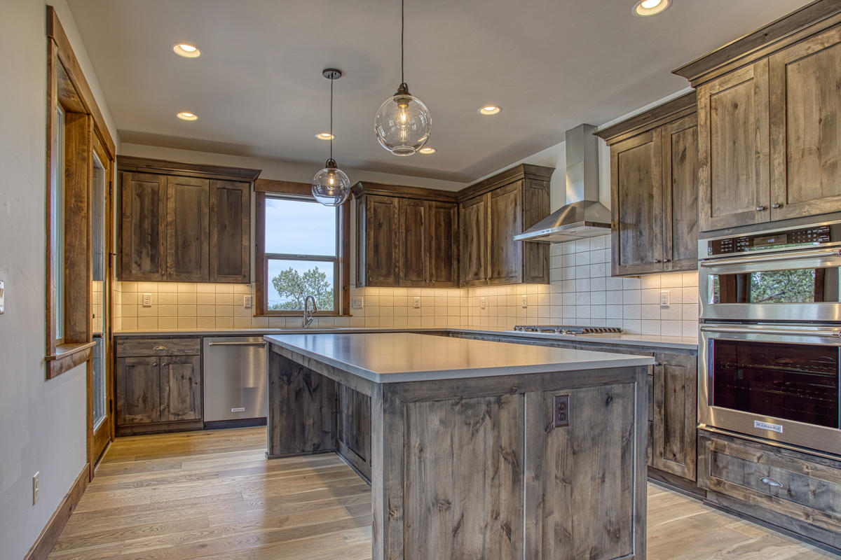 15751 South W Brasada Ranch Road, Unit LOT 363 Powell Butte, OR 97753 - Photo 45 of 47 a large kitchen with granite countertop a sink and dishwasher a oven with wooden cabinets