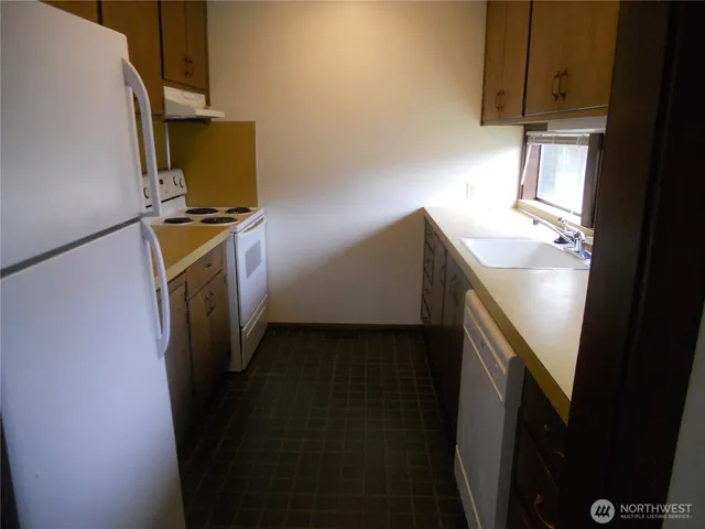a utility room with wooden floor washer and dryer