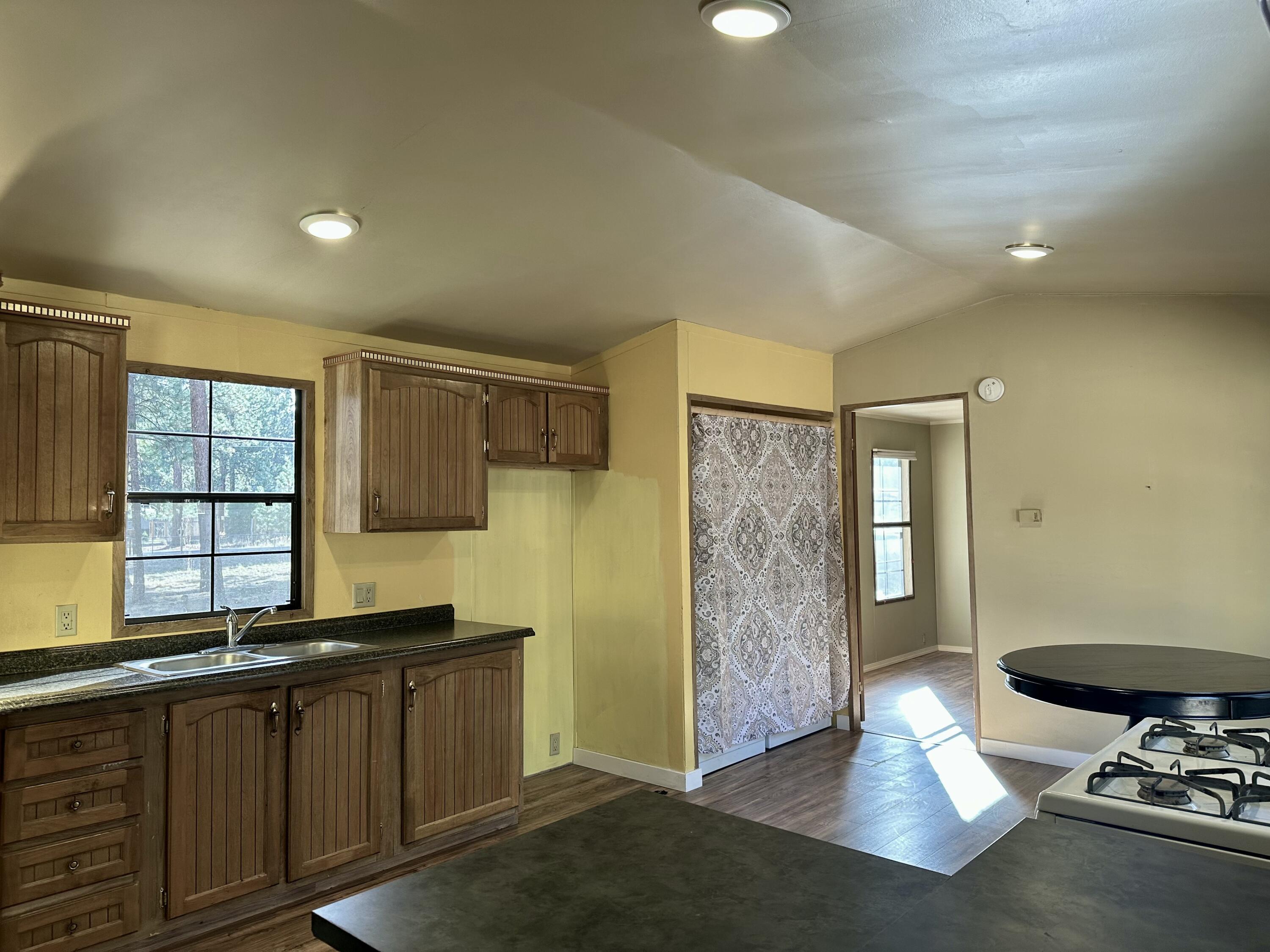 60083 Navajo Road Bend, OR 97702 - Photo 9 of 20 Bright, spacious kitchen flows to living with laundry area behind curtain