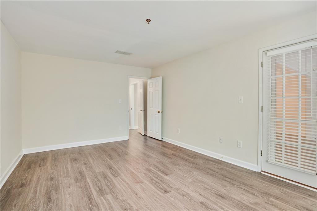 3203 Lenox Road Northeast, Unit 6 Atlanta, GA 30324 - Photo 11 of 27 a view of an empty room with wooden floor and a window