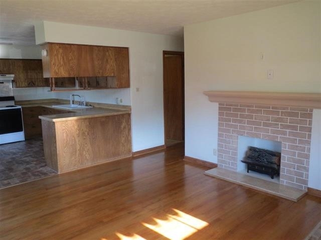 6103 Park Ridge Road Loves Park, IL 61111 - Photo 4 of 22 a kitchen with granite countertop a stove top oven a sink and a wooden floors