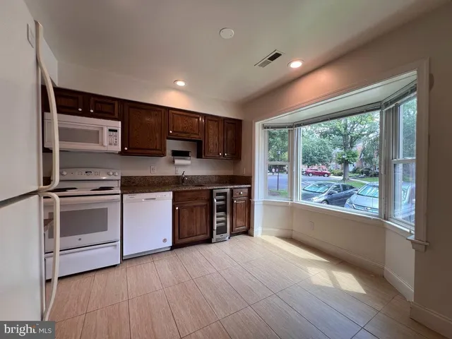 a large kitchen with stainless steel appliances granite countertop a stove a sink and a microwave