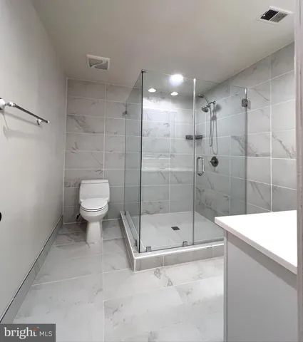 a bathroom with a shower a toilet and a sink