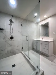 a bathroom with a shower sink and mirror