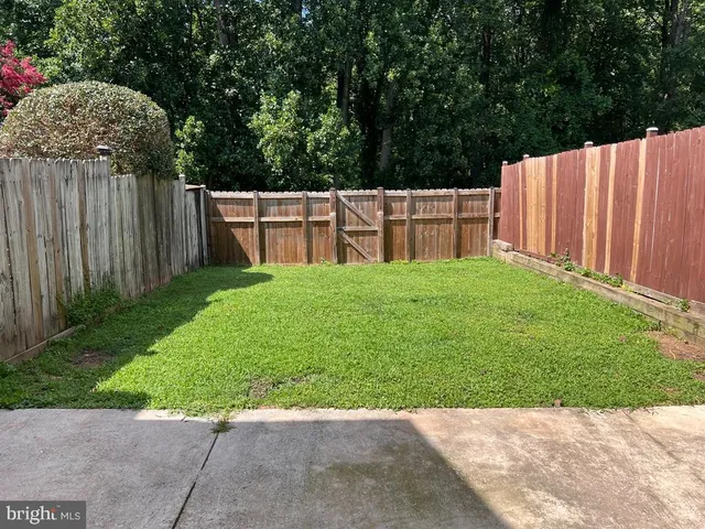 a view of backyard with wooden fence