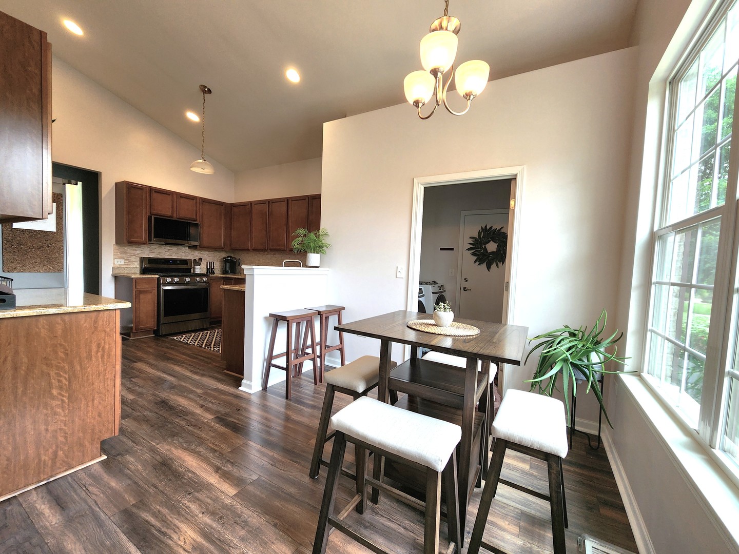 982 Oak Ridge Boulevard Elgin, IL 60120 - Photo 11 of 27 a dining room with wooden floor a chandelier a wooden table and chairs