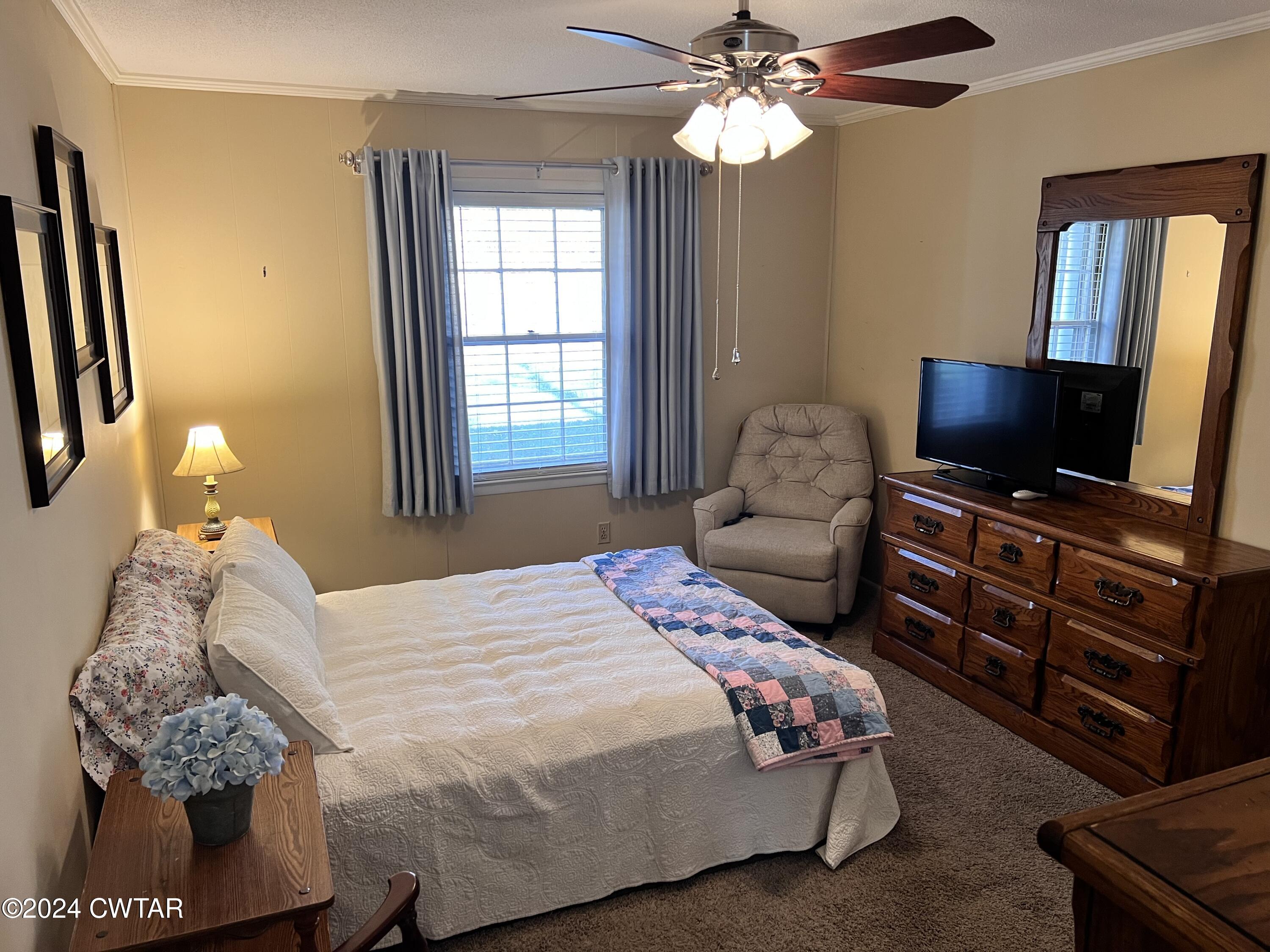 2390 Harts Bridge Road Jackson, TN 38301 - Photo 14 of 36 a bedroom with a bed and a flat screen tv