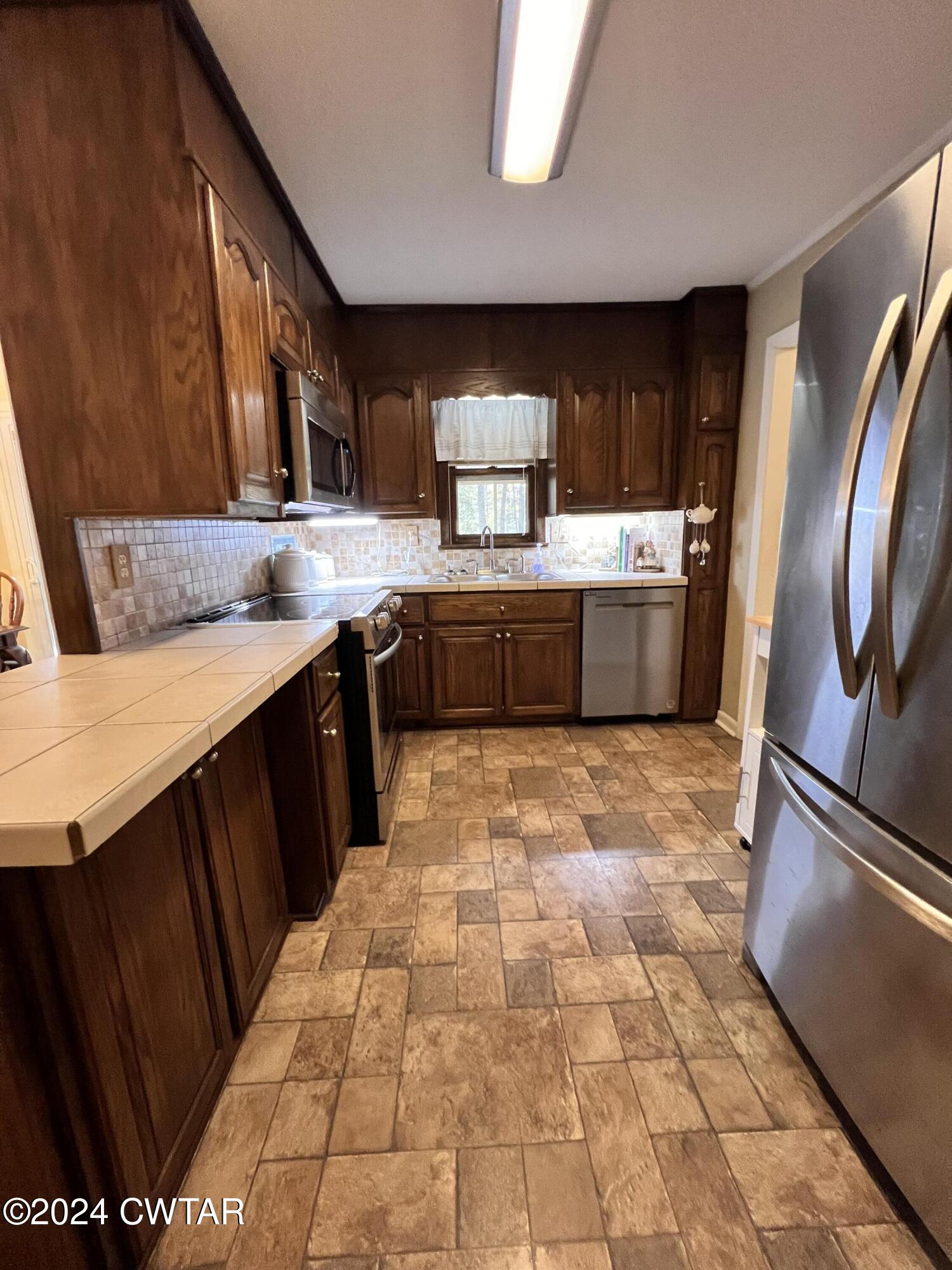 2390 Harts Bridge Road Jackson, TN 38301 - Photo 10 of 36 a kitchen with stainless steel appliances granite countertop a sink stove and refrigerator