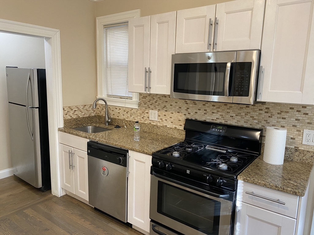 a kitchen with granite countertop a stove and a microwave